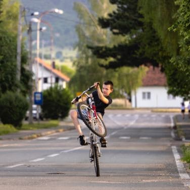 local kid doing wheelie on bike