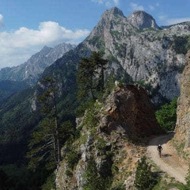 trans balkan road with bikepaking cyclist and landscape with mountains