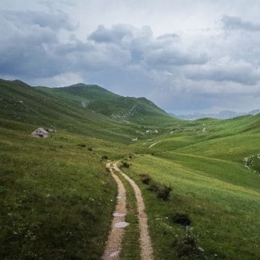 Trans Balkan bikepacking road in pristine landscape with green mountains and ill