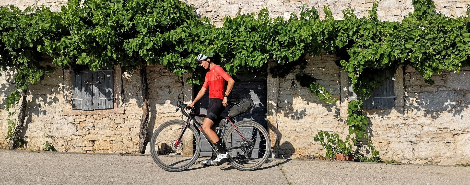 bikepaking cyclist resting on a wall