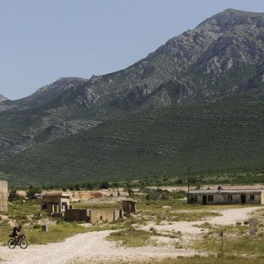 trans balkan road with bikepaking cyclist and landscape with city ruins